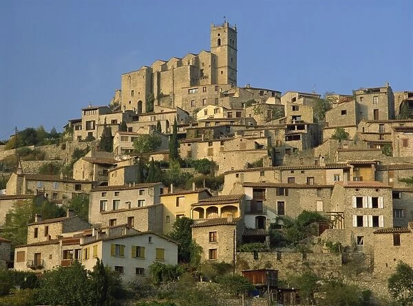 Christian church on the skyline and houses in the village of Eus, Languedoc Roussillon