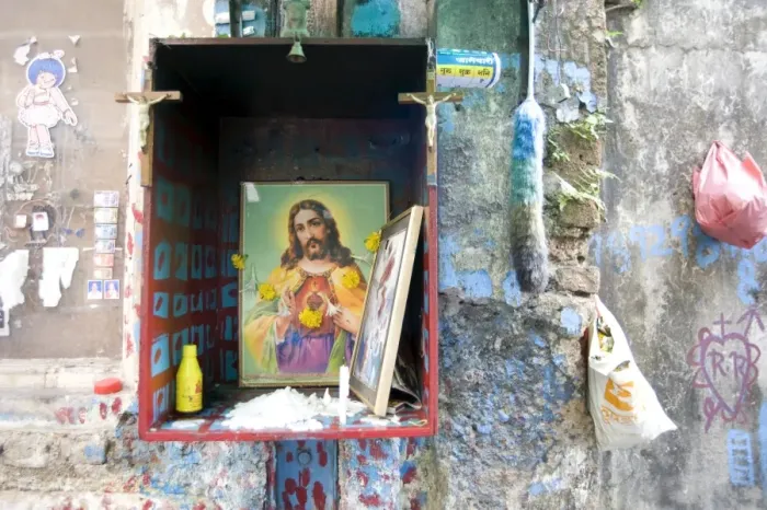 Framed Print : Christian shrine in wooden box on a street wall, with candle, marigolds and offerings Framed Print : Christian shrine in wooden box on a street wall, with candle, marigolds and offerings