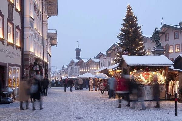 Christmas Market, Christmas tree with stalls and people at Marktstrasse at twilight in the spa town of Bad Tolz, Bavaria