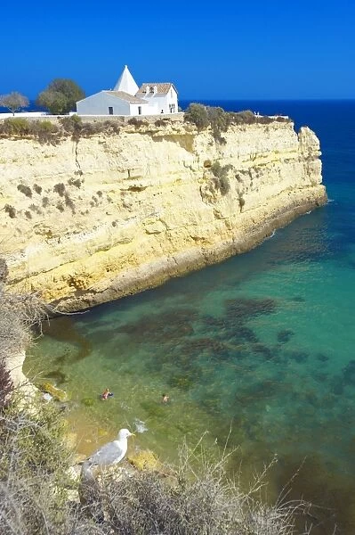 Church on cliff by beach, Algarve, Portugal, Europe