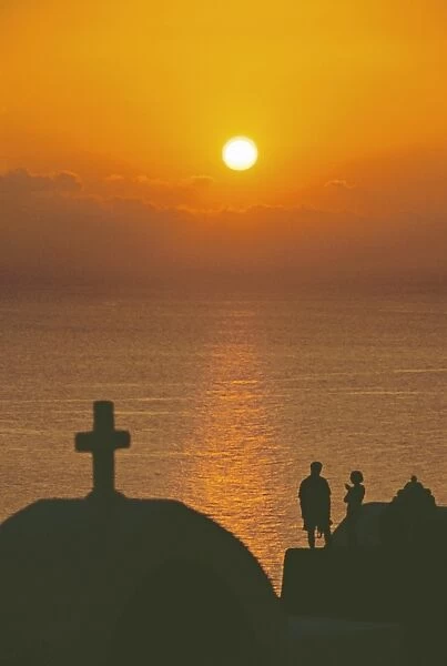 Church and couple silhouetted at sunset, Santorini, Cyclades, Greek Islands