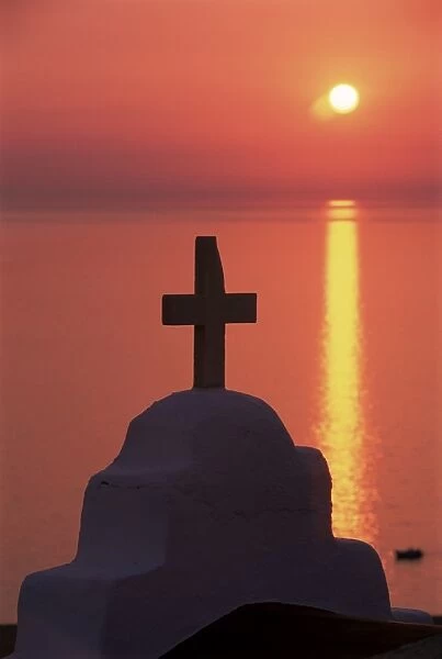Church cross against the sunset