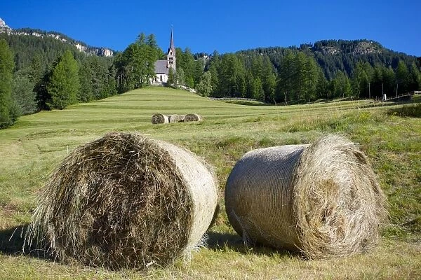 Church and hay bales, Vigo di Fassa, Fassa Valley, Trento Province, Trentino-Alto Adige  /  South Tyrol, Italian Dolomites, Italy, Europe