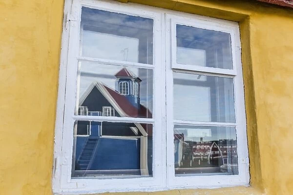 Church reflected in brightly painted house window in Sisimiut, Greenland, Polar Regions