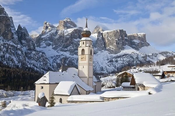 The church and village of Colfosco in Badia, 1645, and Sella Massif range of mountains under winter snow, Dolomites, South Tirol, Trentino-Alto Adige