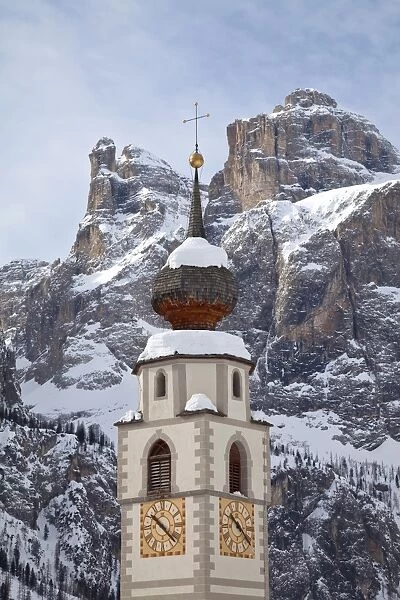 The church and village of Colfosco in Badia, 1645m, and Sella Massif range of mountains under winter snow, Dolomites, South Tirol, Trentino-Alto Adige