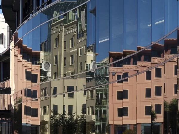 City council buildings in Civic Square reflecting in glass wall of public library, Wellington, North Island, New Zealand, Pacific