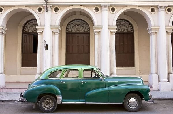 Classic green American car parked outside The National Ballet School, Havana