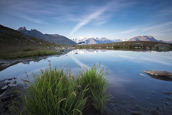 The clear sky is reflected in the blue alpine lake, Muottas Muragl, Samedan, Canton of Graubunden