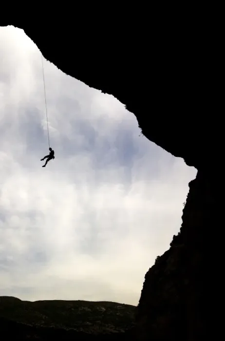 Framed Print : A climber is lowered from a the edge of a huge cave in the Mascun Gorge Framed Print : A climber is lowered from a the edge of a huge cave in the Mascun Gorge