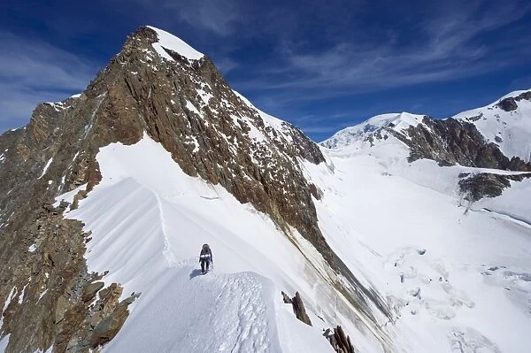 Climber on snow ridge, Aiguille de Bionnassay on the route to Mont Blanc