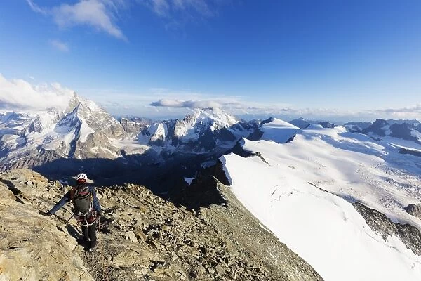 Climber on south ridge of Dent Blanche, 4357m, with view to the Matterhorn, Valais