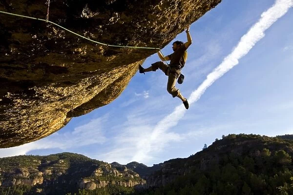 A climber tackles an exceptionally difficult, F8c graded, route on a big overhang at the cliffs of Margalef, underneath Montsant, near Lleida and Tarragona, Catalunya