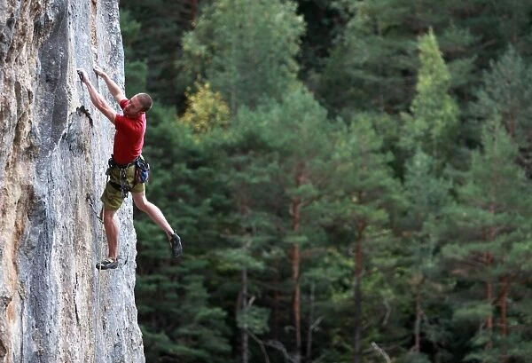 A climber tackles a steep route on limestone cliffs near the mountain town of Bielsa
