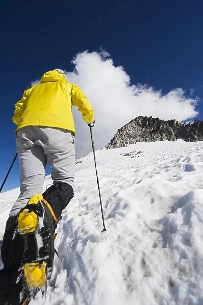 A climber walking up a snowfield, Pico de Aneto, the highest peak in the Pyrenees