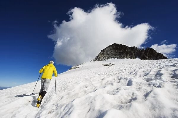 A climber walking up a snowfield, Pico de Aneto, at 3404m the highest peak in the Pyrenees
