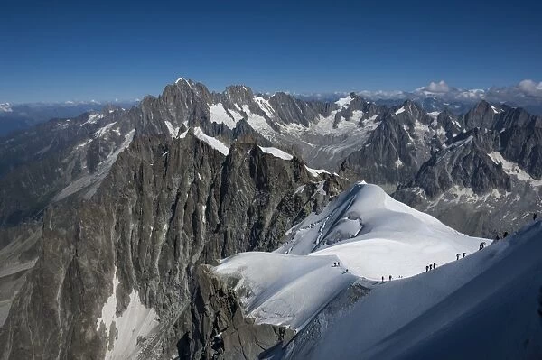 Climbers on a snowfield approaching the Aiguile du Midi, 3842m, Graian Alps, Chamonix