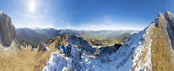 Climbers on steep crest covered with snow in the Ammergau Alps, Tegelberg, Fussen