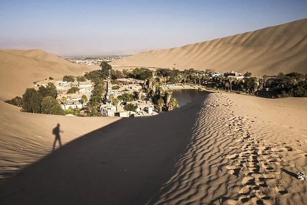 Climbing sand dunes at sunset at Huacachina, a village in the desert, Ica Region