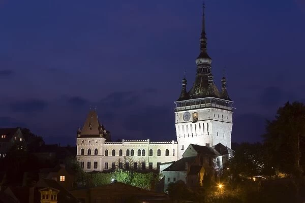 Clock tower (Turnul cu Ceas), illuminated at dusk, formerly the main entrance to the fortified city