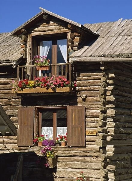 Close up of the exterior of a wooden house with window boxes in St. Veran in the Haute Alpes in Provence