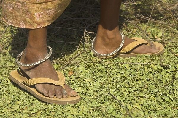 Close up of female farmers feet standing on henna leaves