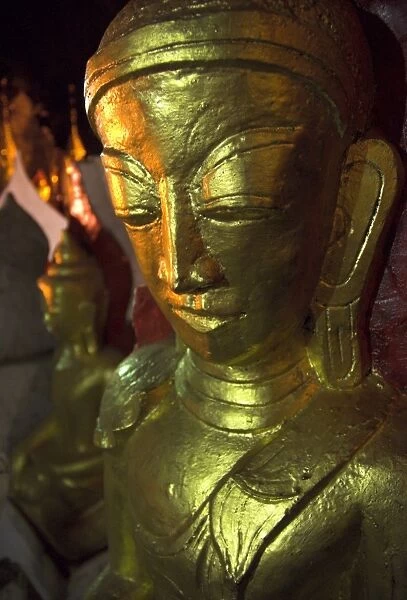 Close up of a large golden Buddha in artificial light, Pindaya Natural Cave Museum