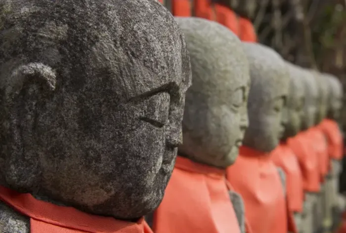 Framed Print : Close up of a row of stone figures wearing red cloth Framed Print : Close up of a row of stone figures wearing red cloth