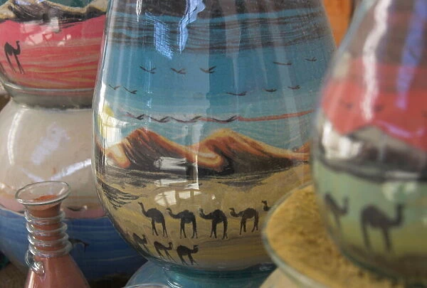Close up of sand bottles with camels in landscapes