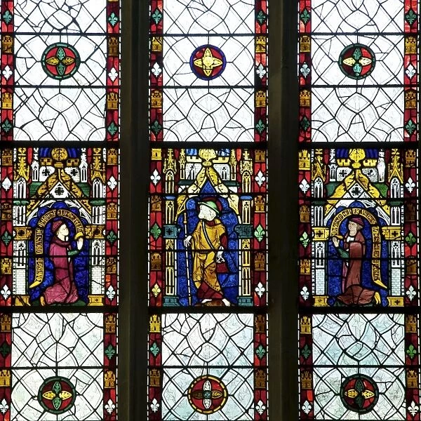 Close-up of 13th and 14th century stained glass windows of saint with kneeling patrons