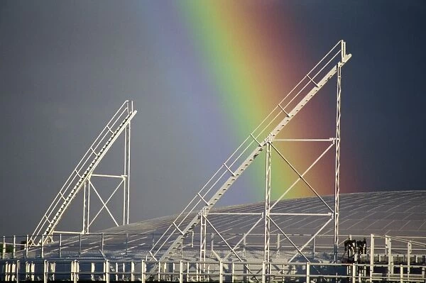Close-up of the end of a rainbow over a gasometer at Richmond, near London
