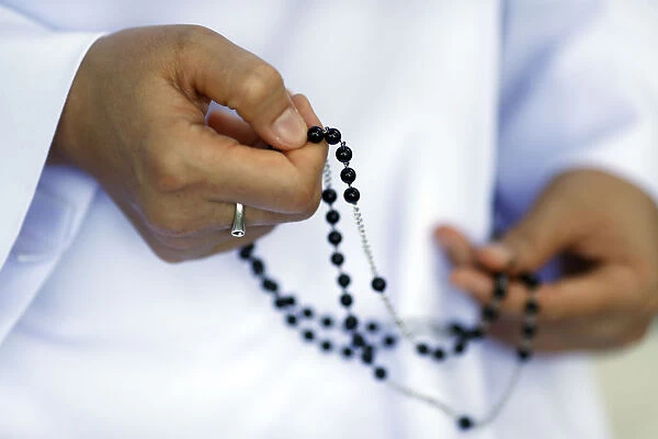 Close-up of hands of Dominican nun praying the rosary beads, Vietnam, Indochina