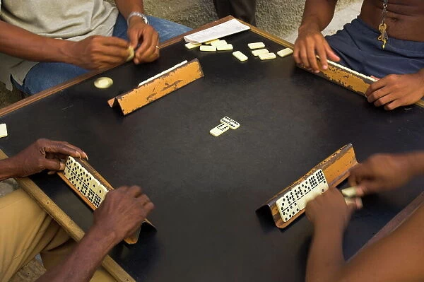 Close-up of the hands of a group of four people playing dominos in the street Centro Habana