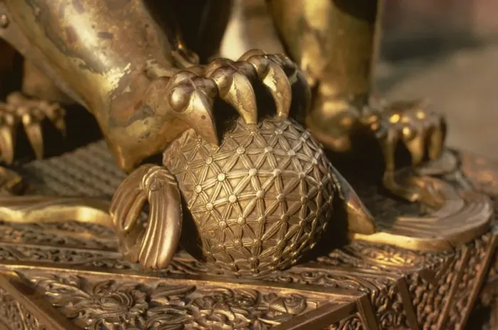 Framed Print : Close-up of the paw of a gilt bronze lion holding a fire ball, symbol of force Framed Print : Close-up of the paw of a gilt bronze lion holding a fire ball, symbol of force
