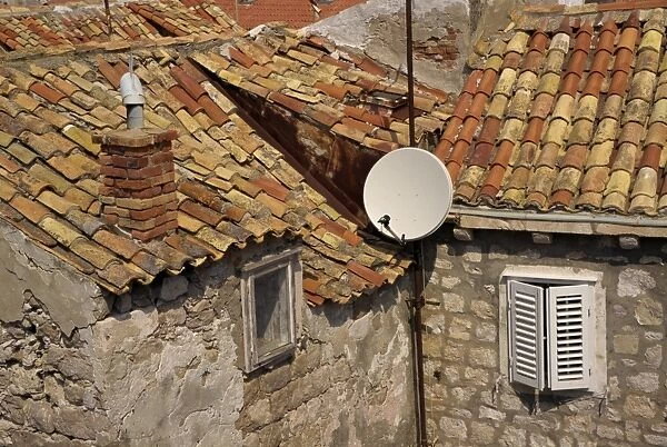 Close-up of roof tiles, old stone walls and satellite dish in the old town of Dubrovnik