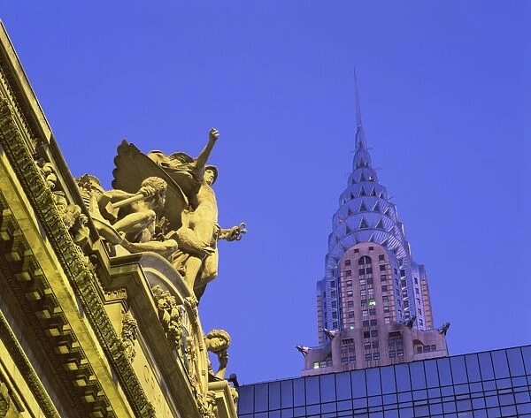 Close-up of statues on top of Grand Central Station, with the Chrysler Building in the background