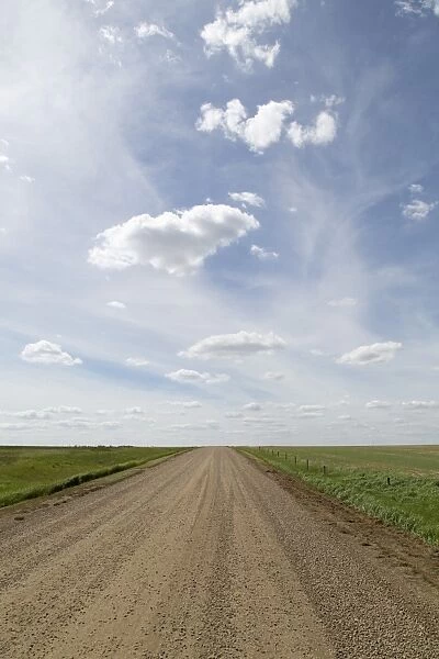 Clouds and blue sky over a dirt track in the Badlands of Alberta, near Drumheller
