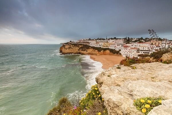Clouds on Carvoeiro village surrounded by sandy beach and turquoise sea, Lagoa Municipality