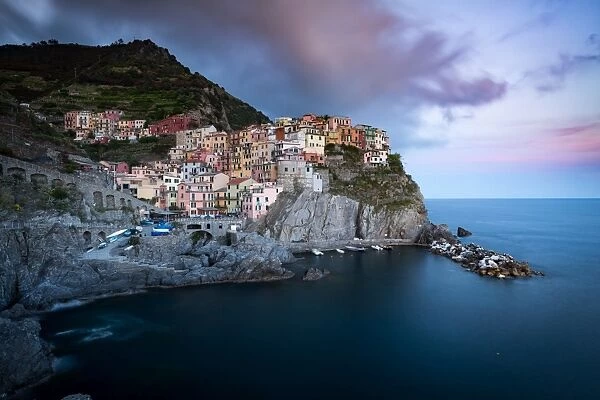 The clouds over Manarola light up with the colours of sunset during a long exposure
