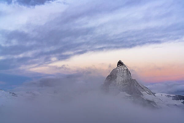 Clouds over Matterhorn peak emerging from mist at sunrise, Gornergrat, Zermatt, canton of Valais, Switzerland, Europe