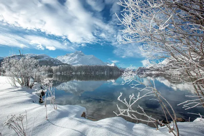 Framed Print : Clouds over snowy woods on shores of frozen Lake Sils in winter, Engadine, Canton of Graubunden, Switzerland, Europe