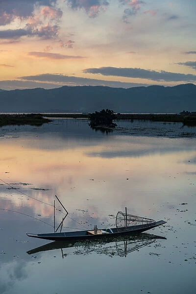 Clouds and traditional rowing boat reflecting in the water at sunset, Inle Lake