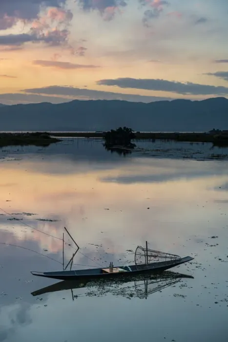 Framed Print : Clouds and traditional rowing boat reflecting in the water at sunset, Inle Lake