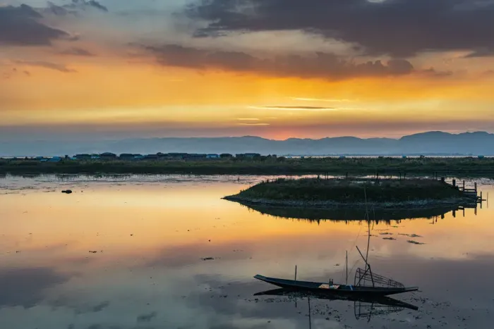 Framed Print : Clouds and traditional rowing boat reflecting in the water at sunset, Inle Lake
