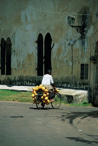 Coconut seller riding his bicycle