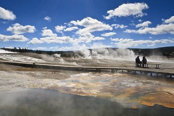 Cold tourists on seat surrounded by steam, Upper Geyser Basin, Yellowstone National Park, UNESCO World Heritage Site, Wyoming, United States of America, North America