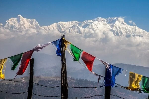Colored prayer flags flutter in front of the majestic Kanchenjunga, the third highest