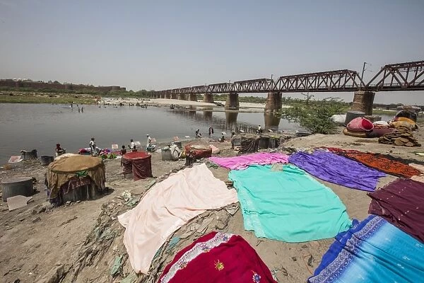 Colorful clothes drying in the sun on the banks of the River Yamuna, a polluted tributary