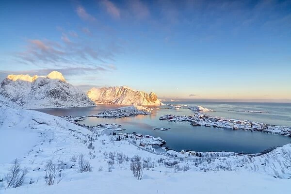 The colors of dawn frame the fishing villages surrounded by snowy peaks, Reine, Nordland