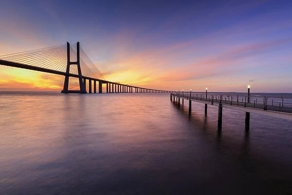 The colors of dawn on Vasco da Gama Bridge that spans the Tagus River, Lisbon, Portugal